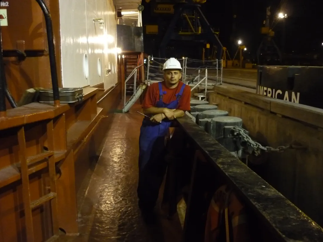 Andrei in boatswain uniform on deck of a Black Sea cargo vessel at port at night, before his appliance repair career in the Bay Area